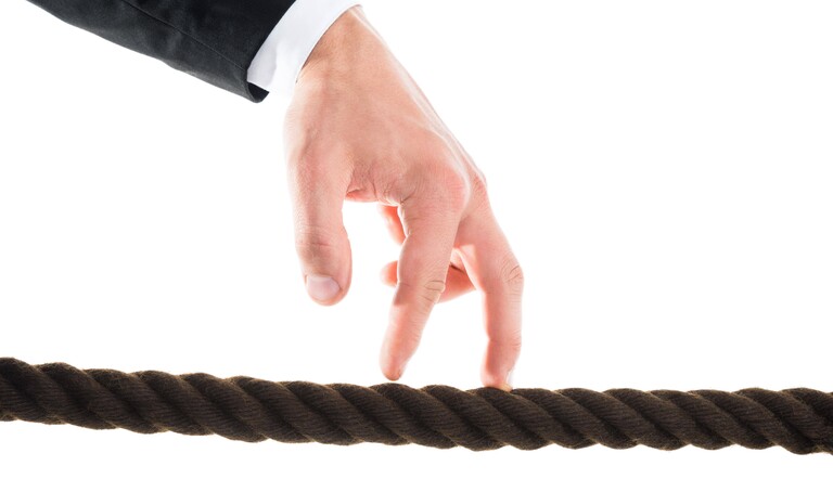 Ein Mann nutzt seine Finger für einen vermeintlichen Drahtseilakt