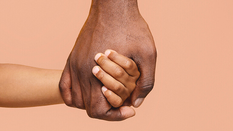 Nahaufnahme der Hand eines Mannes, der das Hand eines Kindes hält