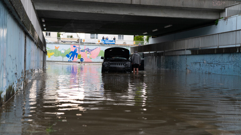 Nach einem heftigen Gewitter im Juni 2023 in Südhessen: ein fahruntüchtiges Auto steht in einer überschwemmten Unterführung