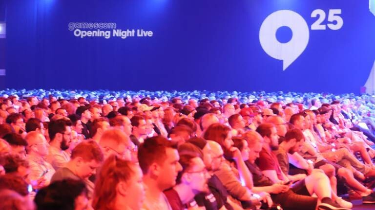 Besucher sitzen in einer Messehalle zur Gamescom Opening Night Live