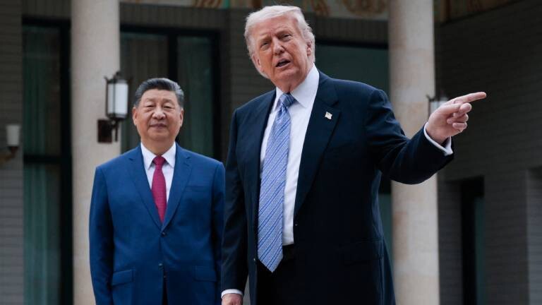 US-Präsident Donald Trump (R) gestikuliert, während er am 15. Mai 2026 bei einem Besuch im Zhongnanhai-Garten in Peking für Fotos mit dem chinesischen Präsidenten Xi Jinping posiert.