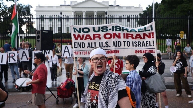 Demonstranten halten Schilder hoch, um gegen die israelischen Angriffe auf den Iran und eine mögliche Beteiligung der USA an dem Konflikt zu protestieren. Dies geschieht während einer „Kein Krieg gegen den Iran“-Demonstration vor dem Weißen Haus in Washington, D.C. am 18. Juni 2025.