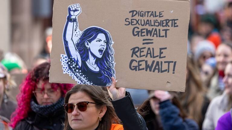 Solidaritätskundgebung mit Collien Fernandes und gegen sexualisierte digitale Gewalt. Auf einer Demo in Nürnberg, Deutschland, hält eine Frau ein Protestschild mit der Aufschrift Digitale sexualisierte Gewalt = reale Gewalt! hoch. Auf dem Schild ist zudem eine grafische Darstellung einer Frau mit erhobener Faust zu sehen.