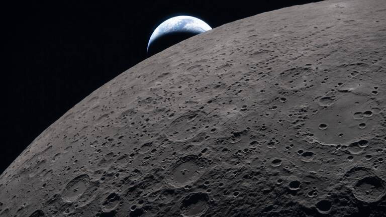 Das Bild zeigt die Mondoberfläche beim Vorbeiflug der Artemis-II-Mission zu sehen. Der Planet Erde ist im Hintergrund.