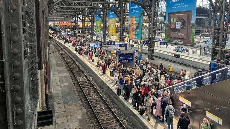 Hamburger Hauptbahnhof, volle Bahnsteige mit wartenden Reisenden, laufende Sanierungsarbeiten beeinflussen den Betrieb, große Menschenmengen auf den Gleisen (Symbolbild)