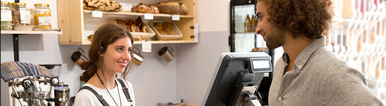 Zwei Menschen unterhalten sich in einer Bäckerei.
