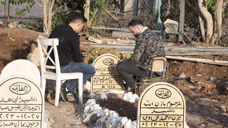 Zwei Männer an einem Grab